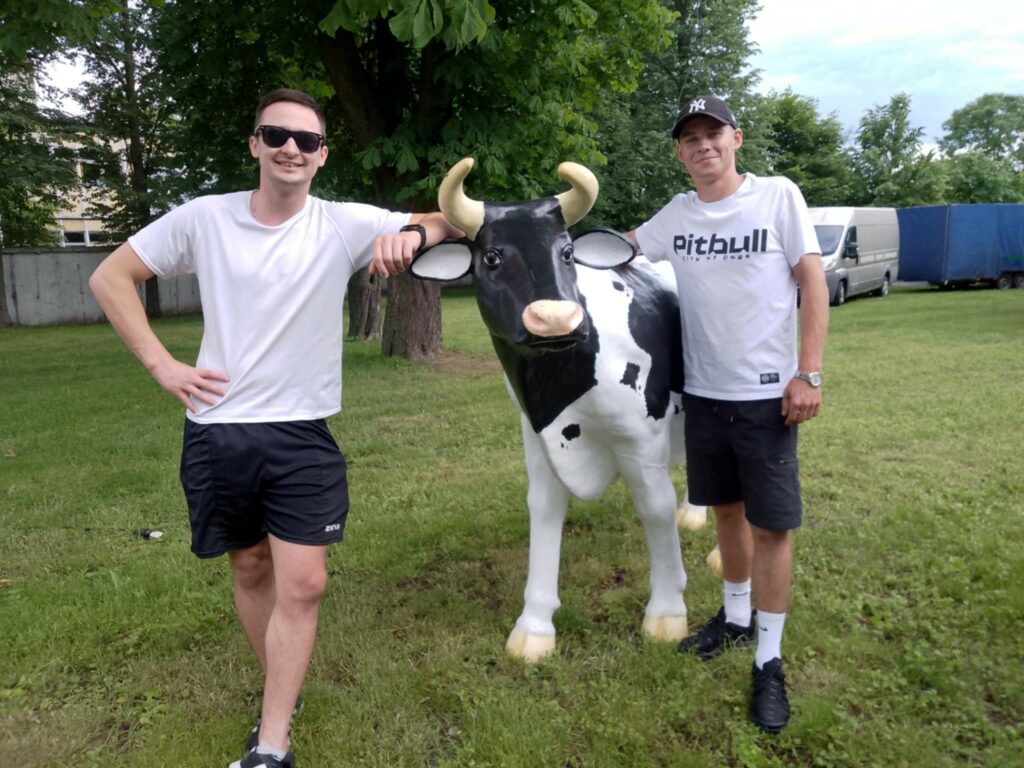 dwóch chłopaków przy jednej z atrakcji pikniku-sztucznej krowie 