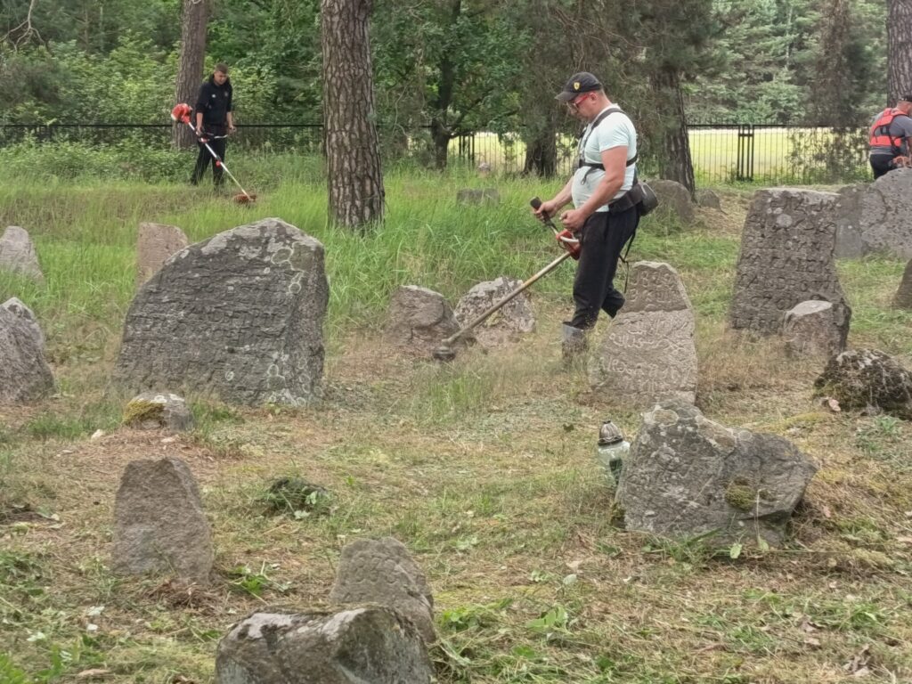 Osoby koszące trawę na cmentarzu tatarskim 